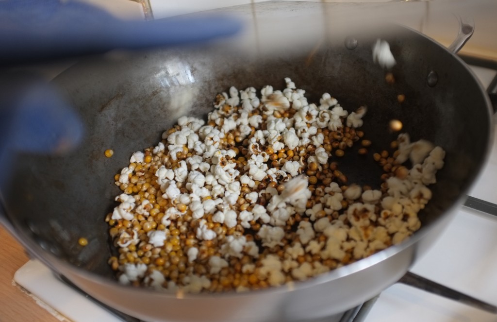 Sous le couvercle de la poêle, les grains de maïs se transforment en pop corn