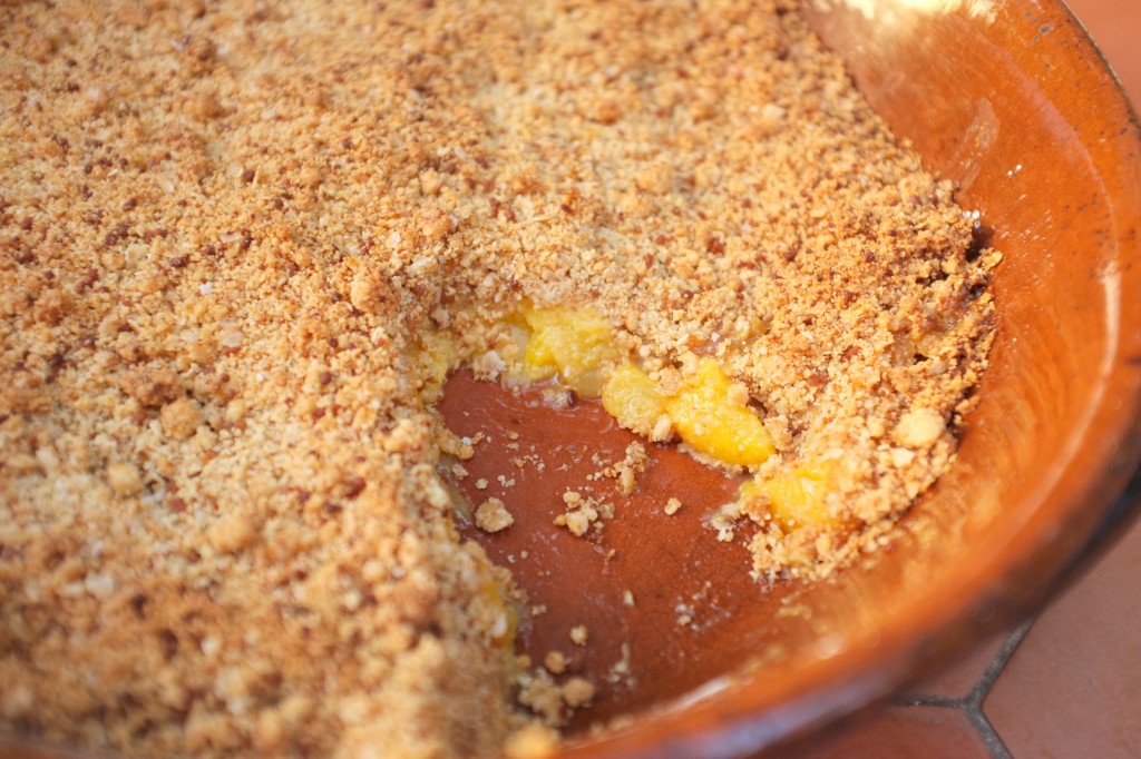 Sous la croute de crumble, les fruits couleur soleil apparaissent