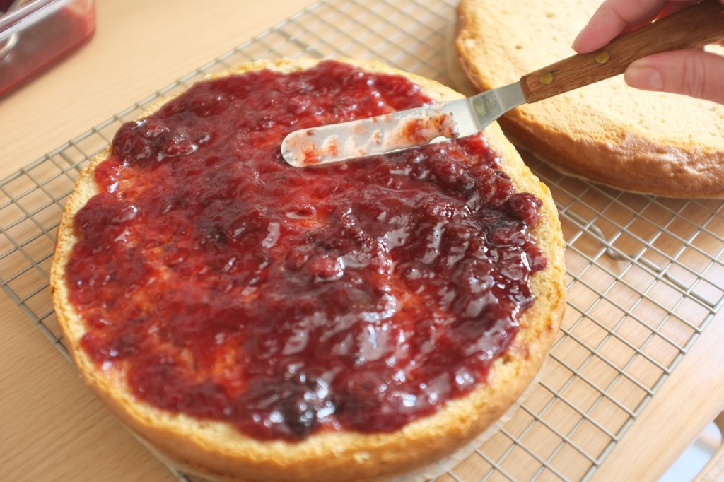 Sur le premier gâteau, le dessus est tartiné de confiture de fraise