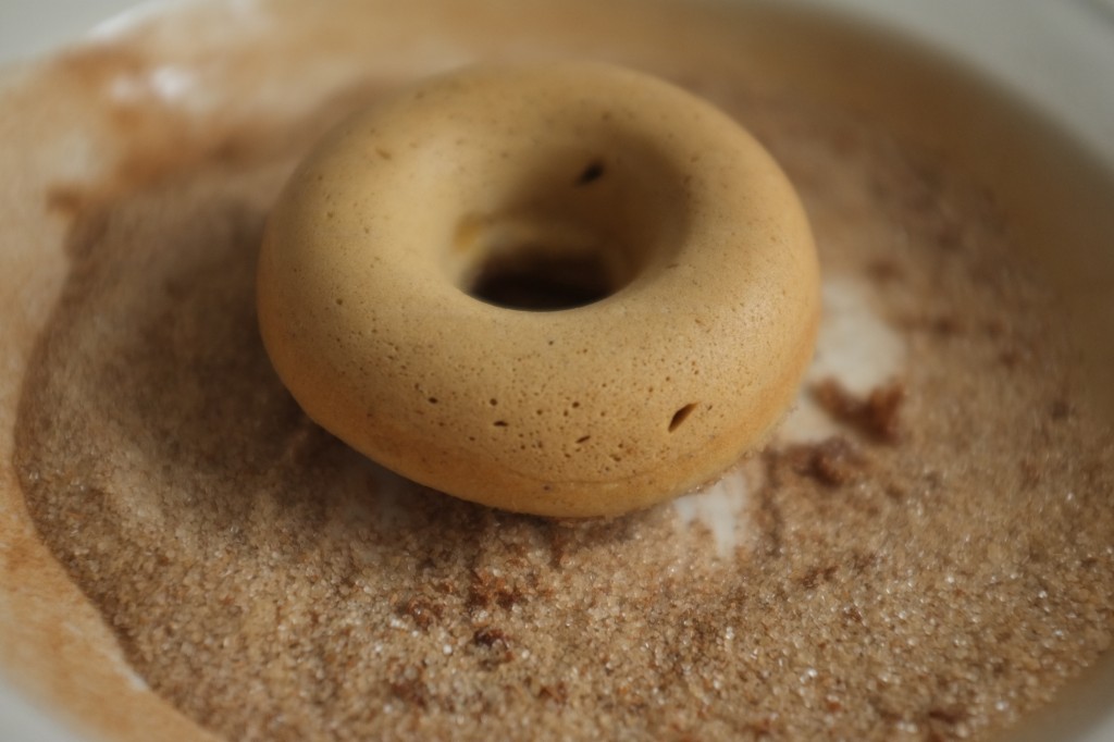 Le donut pré-trempé dans le beurre est ensuite posé dans le sucre à la cannelle