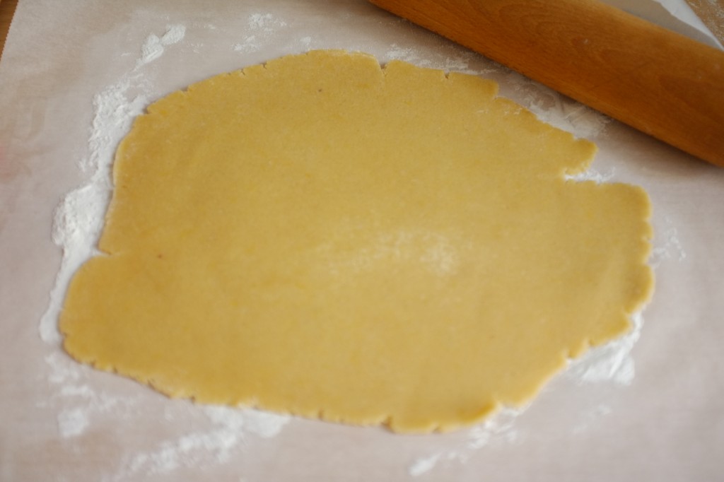 La pâte sans gluten est étalée entre deux feuilles de papier cuisson farinées