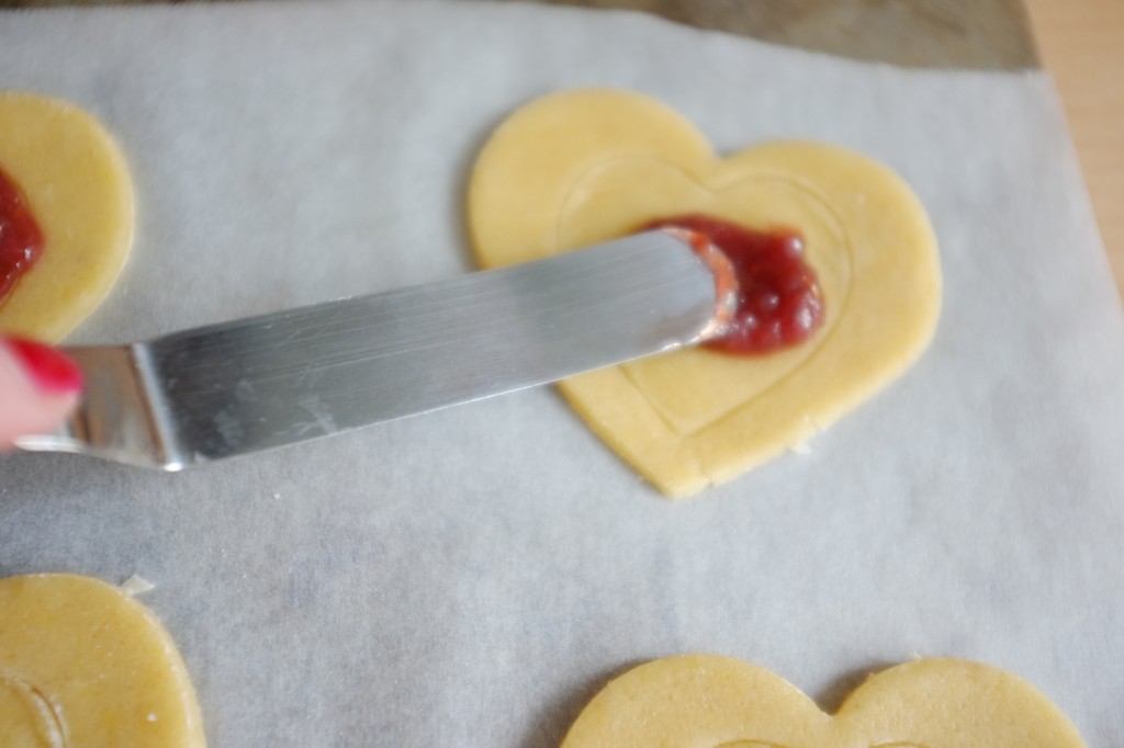 Le glaçage litchi-framboise est étalé délicatement au centre