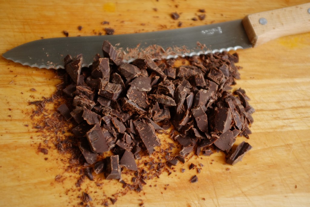 Je coupe la plaque de chocolat noir en petits morceaux à l'aide d'une couteau à pain