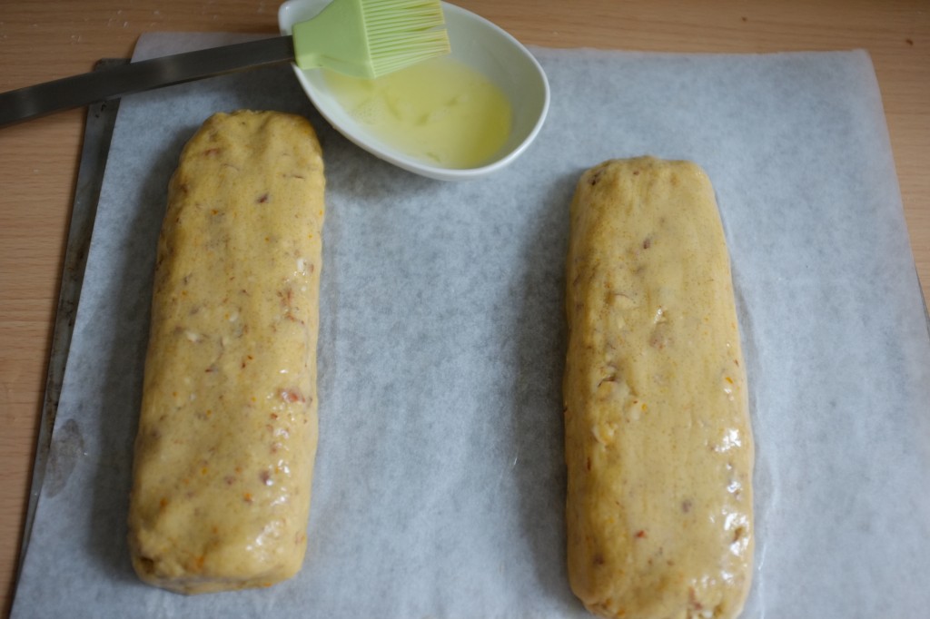 Les pains sans gluten de biscotti, badigeonnés de blanc d'oeuf avant d'être enfournés