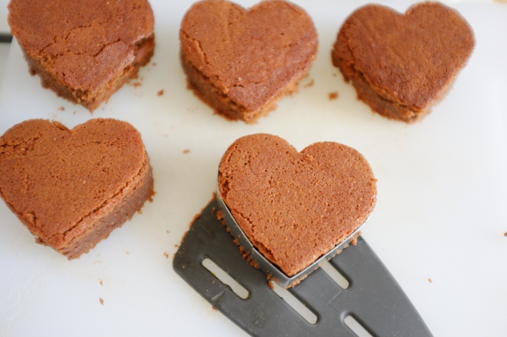 Les brownies sans gluten en forme de coeurs sont déposés sur une autre planche à découper.