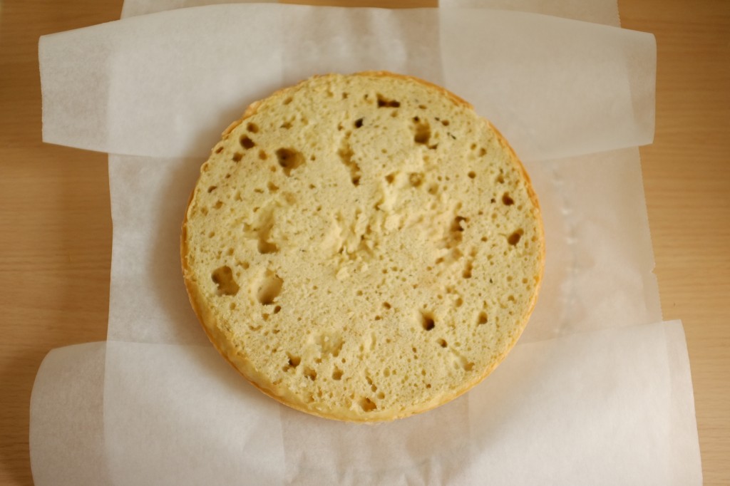 Le premier gâteau est déposé sur la plat de service, lui-même protégé aux bords par des fines feuilles de papier cuisson