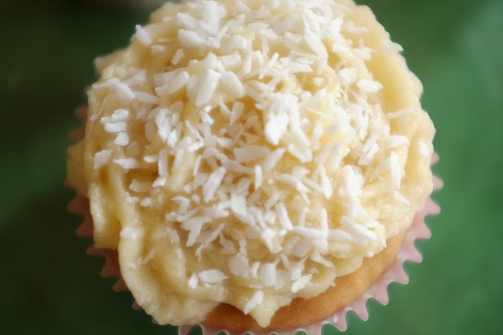 Je saupoudre le cupcake sans gluten et la crème au beurre de noix de coco râpée