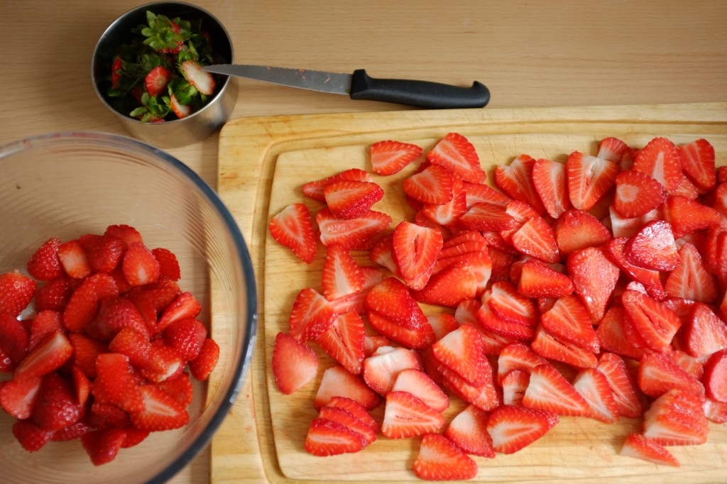 Je coupe les fraises en fines lamelles, et je garde les petits bouts des extrémités pour un autre usage.