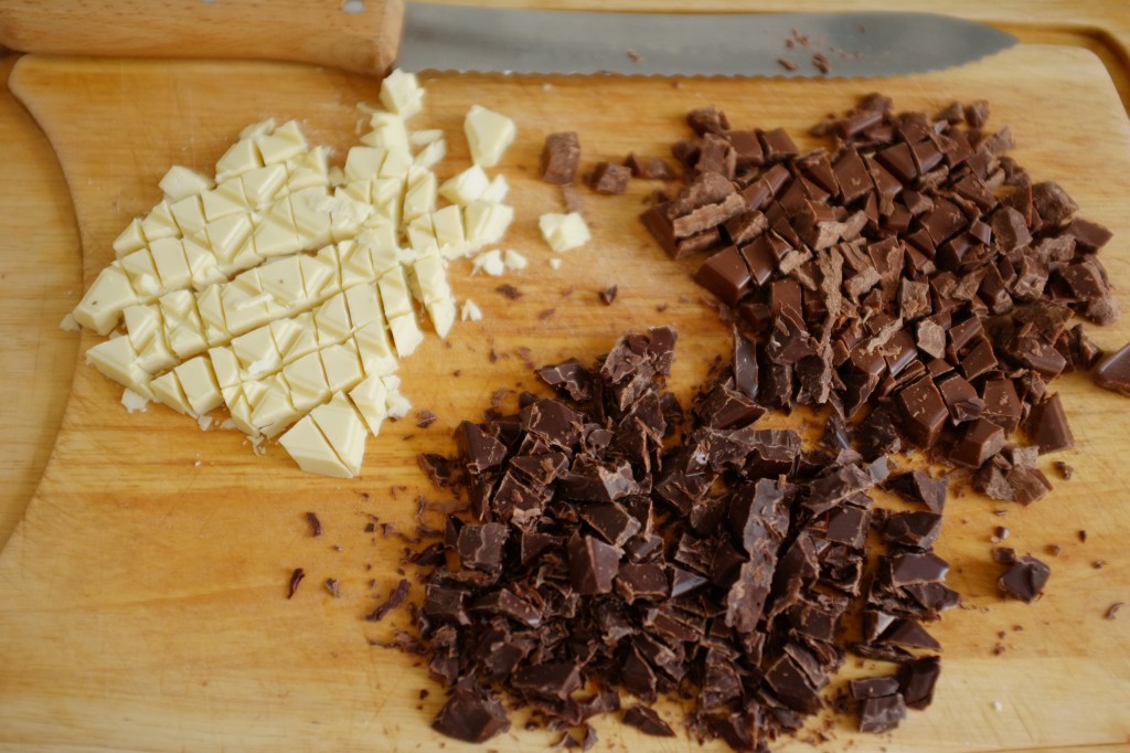 Les 3 chocolats sans gluten sont coupés au couteau à pain pour obtenir les parfaits "éclats de chocolat" pour décorer les cookies.