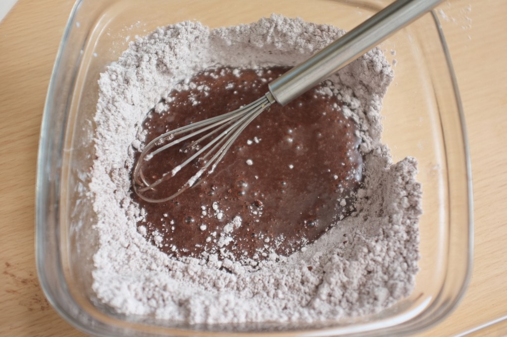 Le sucre glace et le chocolat noir en poudre sans gluten sont mélangés ensemble pour le glaçage au chocolat