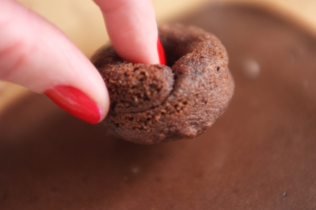 Le mini donut est retourné pour être trempé dans le glaçage au chocolat