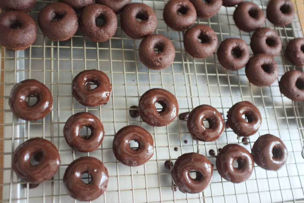 Les mini donuts sans gluten en train d'être glaçés au chocolat