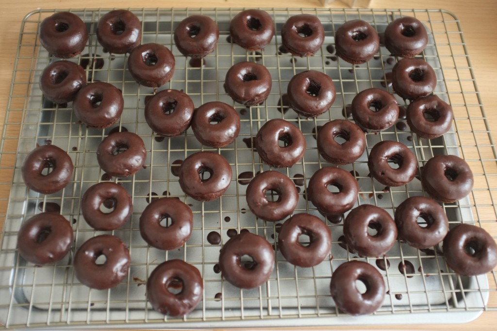 Les mini donuts sans gluten au chocolat, glaçés au chocolat sèchent sur une grille