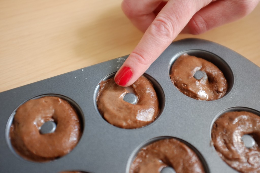 Je lisse avec un doigt mouillé le dessus des mini donuts sans gluten