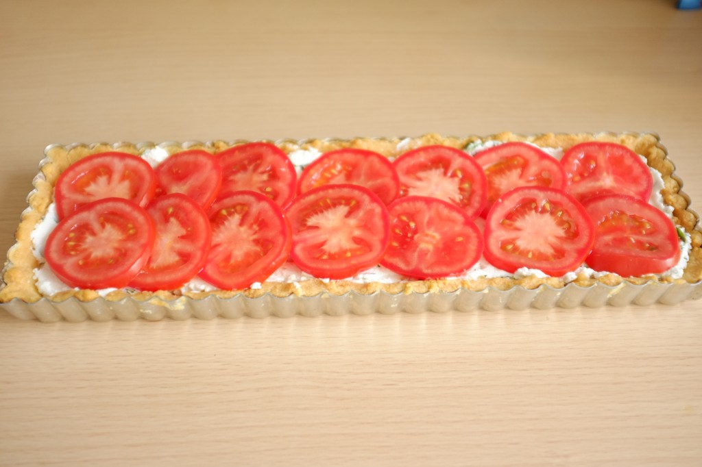 Les rondelles de tomates décorent le dessus de la tarte 