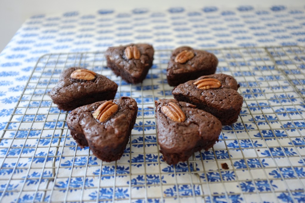 La première fournée des petits brownies aux noix de pécan refroidissent sur une grille