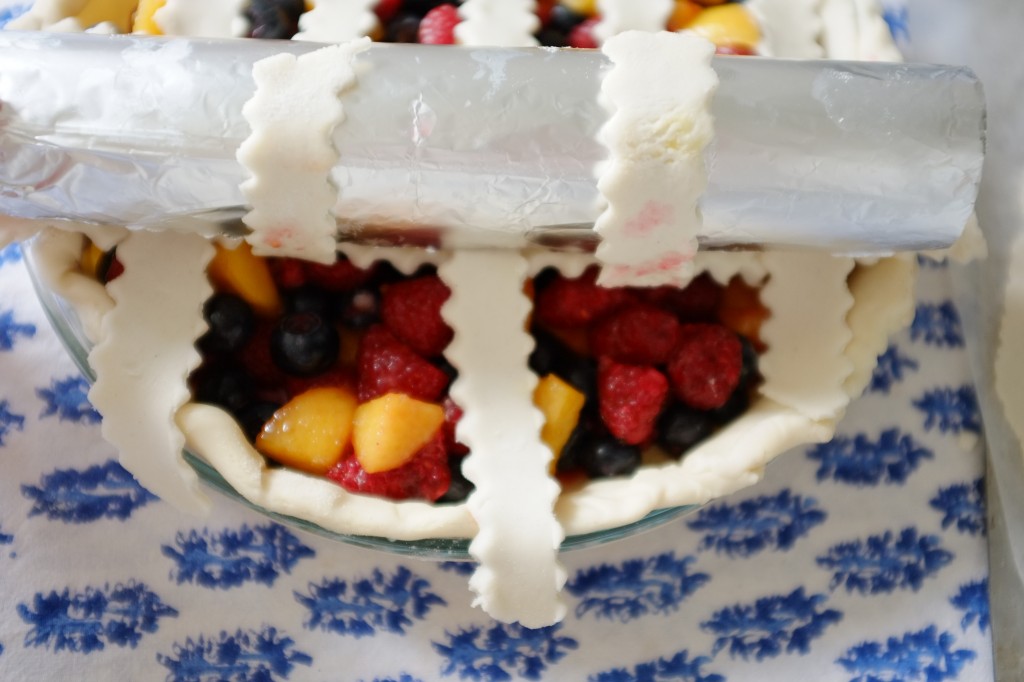 La dernière lamelle de pâte sans gluten est positionnée sur cette moitié de tarte.