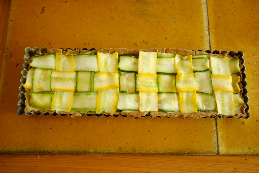 Les lamelles de courgettes sont badigeonnées à l'huile d'olive, la tarte est prête à être enfournée