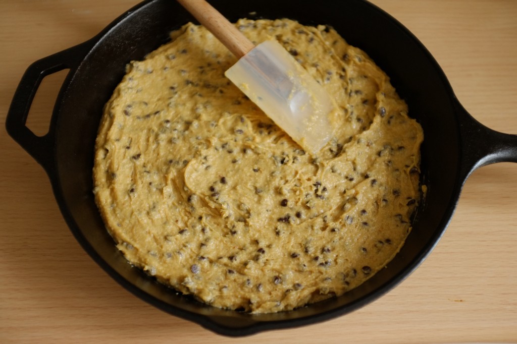 La pâte sans gluten de cookie au chocolat déposé dans une poêle en fonte avant d'être enfournée