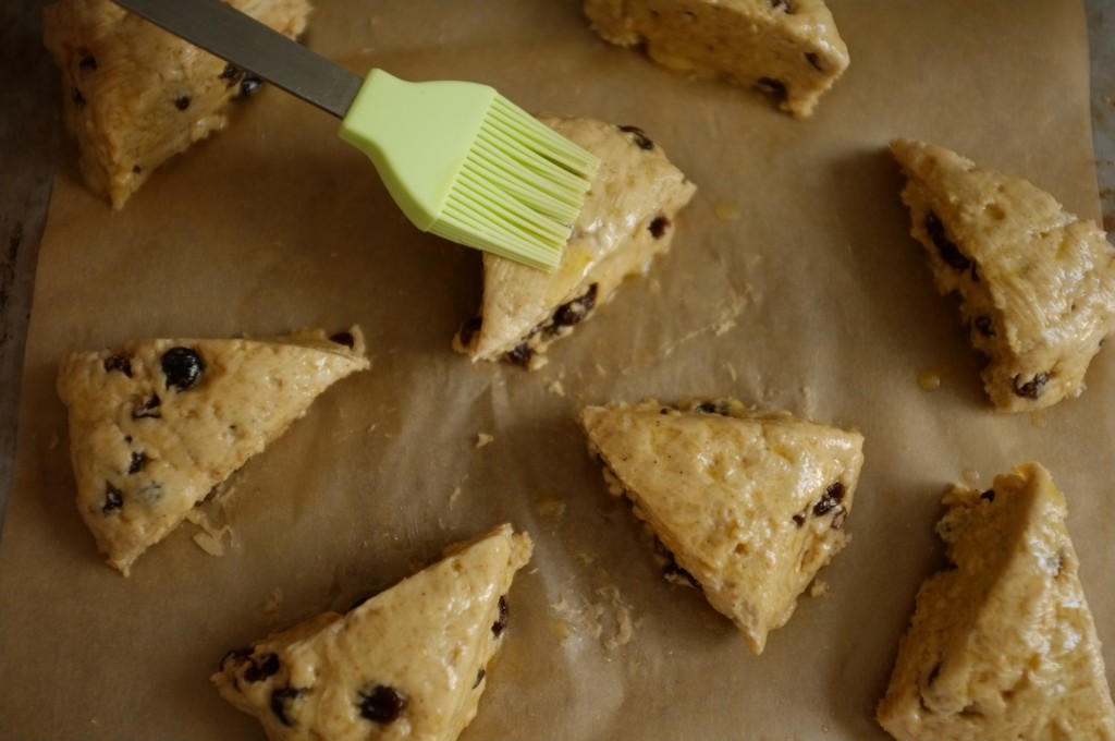 les parts de scones sans gluten sont badigeonnées de beurre fondu