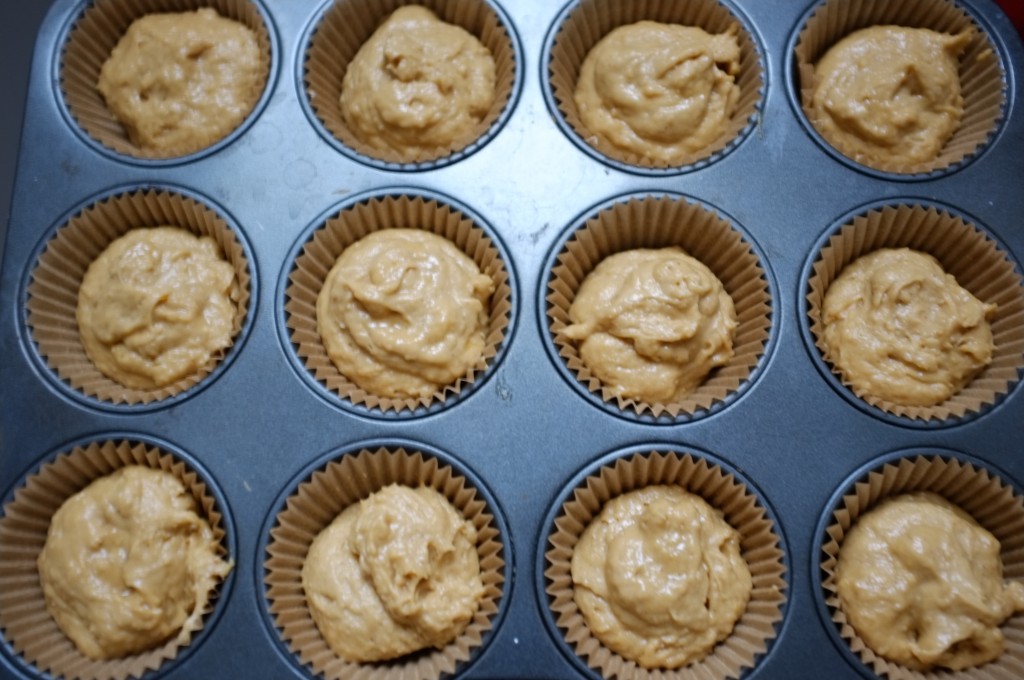 La pâte sans gluten est déposée dans les petits moules en papier de la plaque à muffin