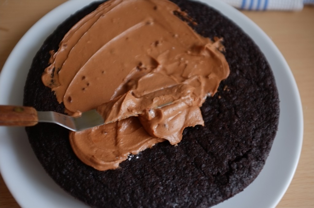 Je recouvre le dessus du premier gâteau de crèeme au beurre parfumé au chocolat et café