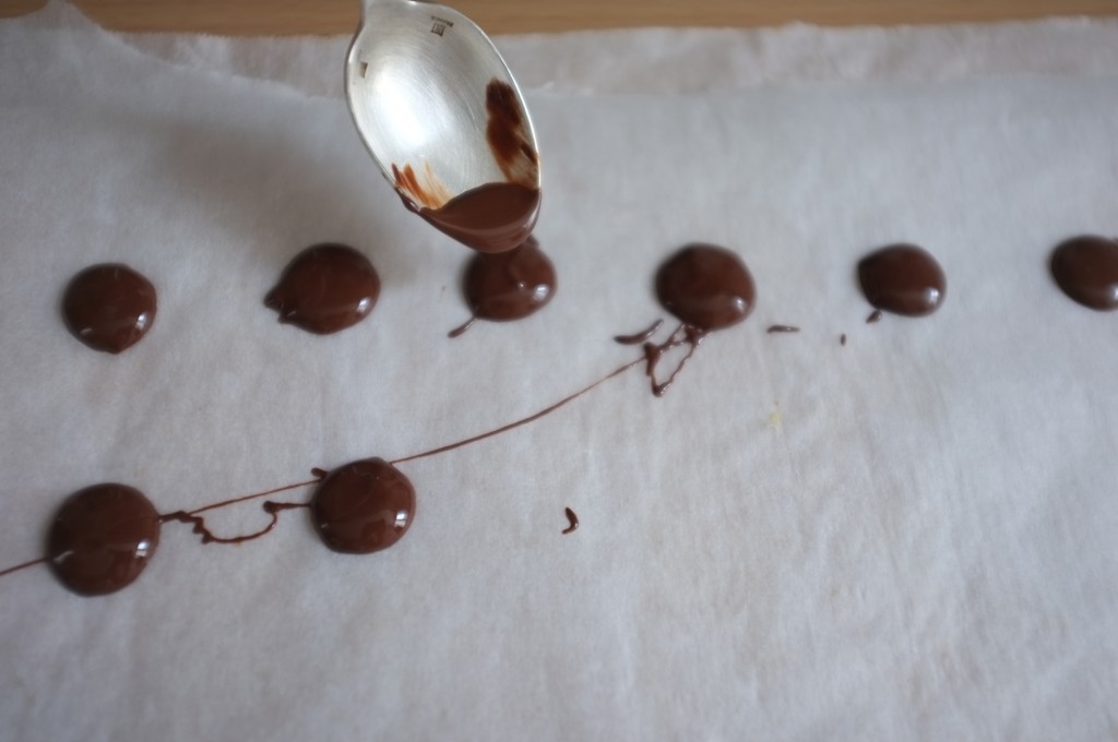 Avec le chocolat fondu, je forme des petites pastilles qui sèchent sur une feuillede papier cuisson.