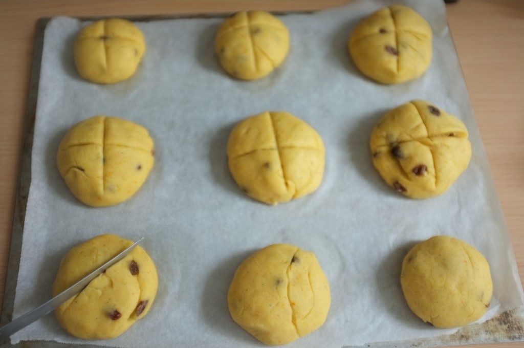 Les petits pains de Pâques sans gluten ont levés pendant 1 heure, je forme alors une croix avec la lame d'un couteau.