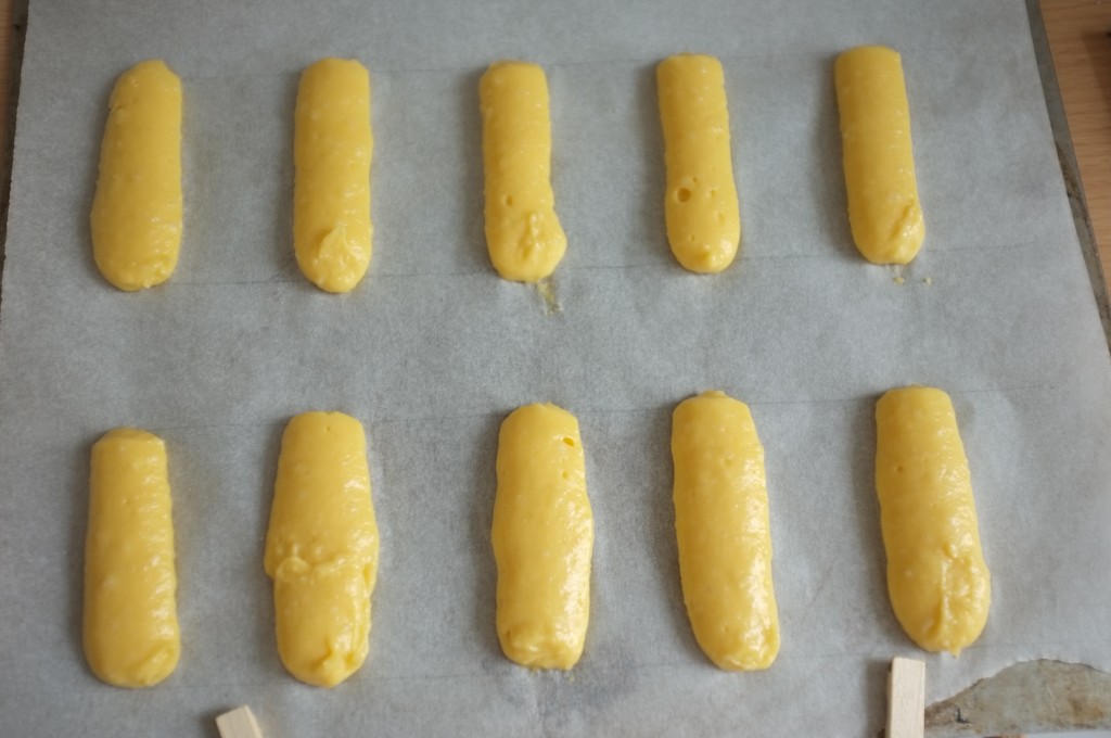 Les minis éclairs sont formés sur la feuille de cuisson, on apperçoit les lignes au crayon que j'ai dessiné à l'envers de la feuille...