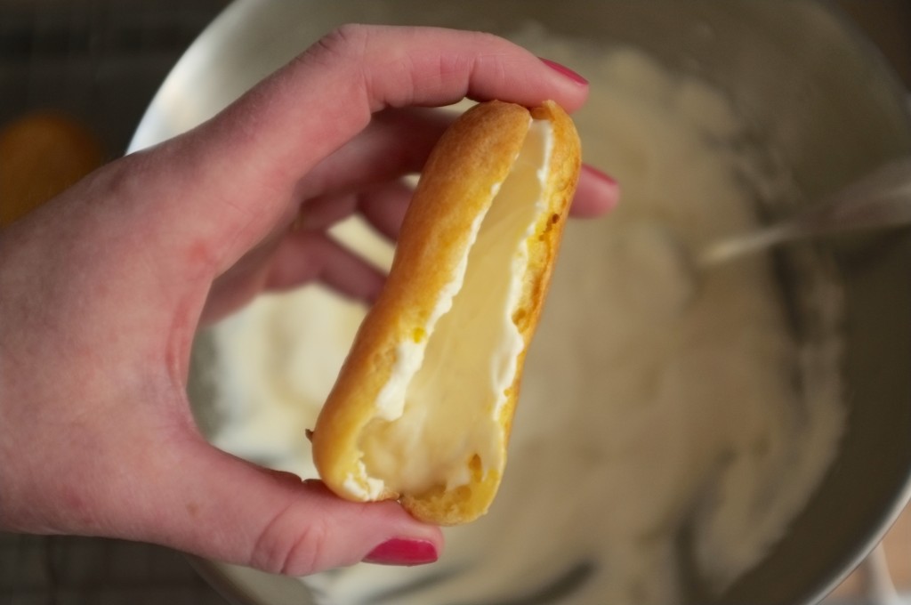 Une ouverture est découpée dans la tranche pour garnie l'intérieur de l'éclair sans gluten de crème fouettée.