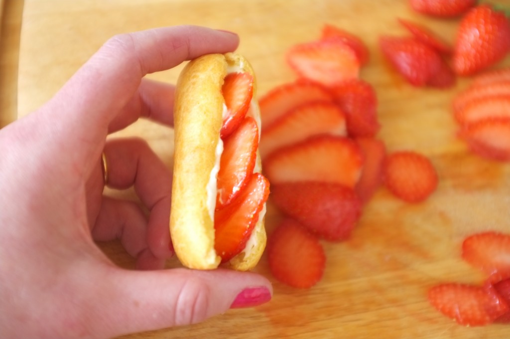 Je glisse quelques fines lamelles de fraises dans le mini éclairs sans gluten