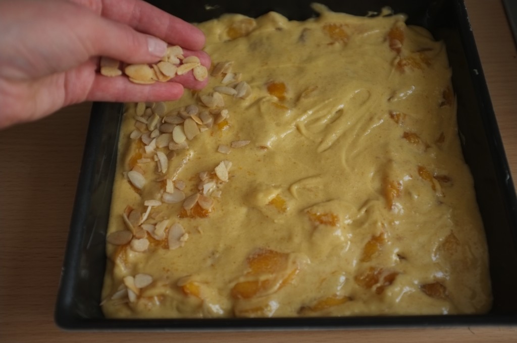 Une fois dans le moule, le gâteau est saupoudré d'amandes effilées légèrement parfumés à la cannelle.