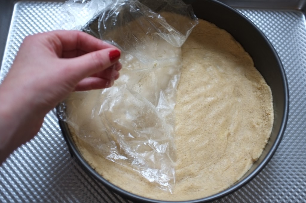 Pour étalerfacilement la pâte sans gluten au fond du moule, j'appuie sur la pâte avec une feuille de film fraîcheur