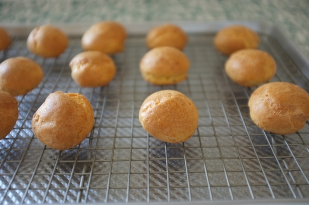 Les petits choux sans gluten refroidissent tranquillement sur une grille.