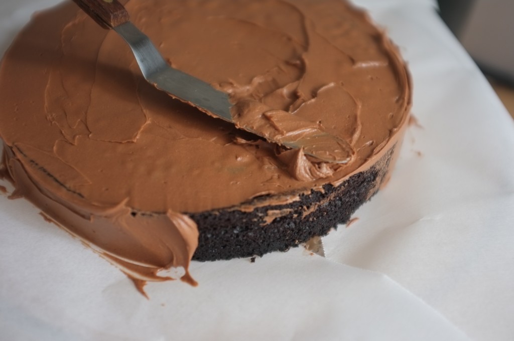 Je recouvre le gâteau au chocolat de crème au beurre au chocolat