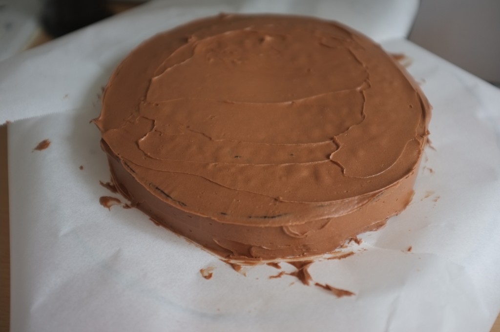 le gâteau sans gluten au chocolat de Pâques est complètement recouvert de crème au beurre.