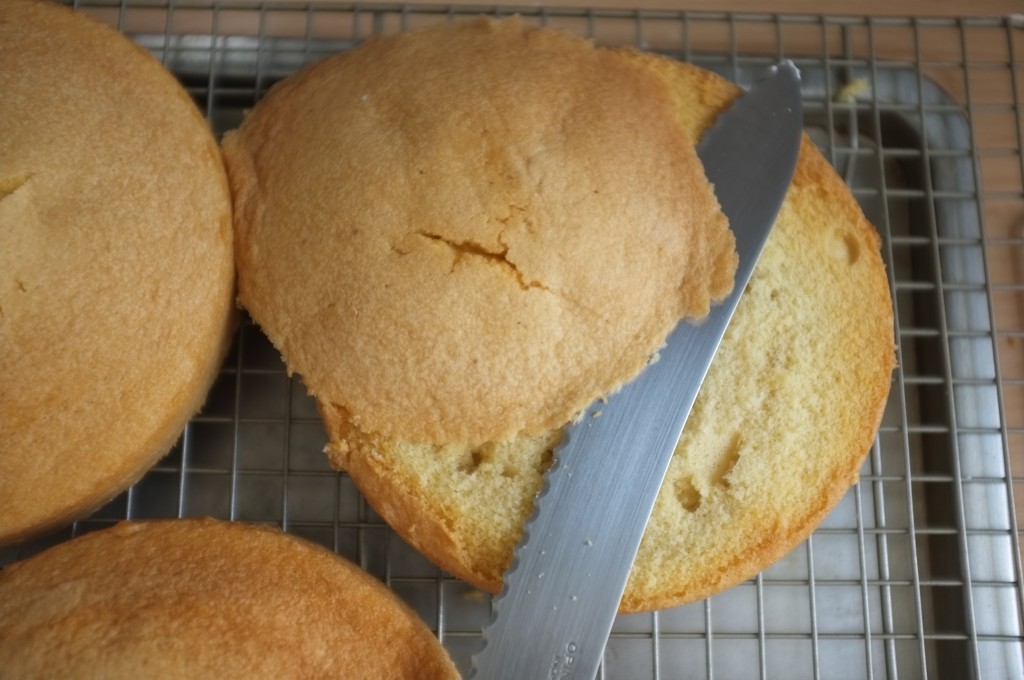 Je coupe, à l'aide d'un couteau à pain, le dessus de chaque gâteau pour laisser apparaitre la génoise sans gluten.