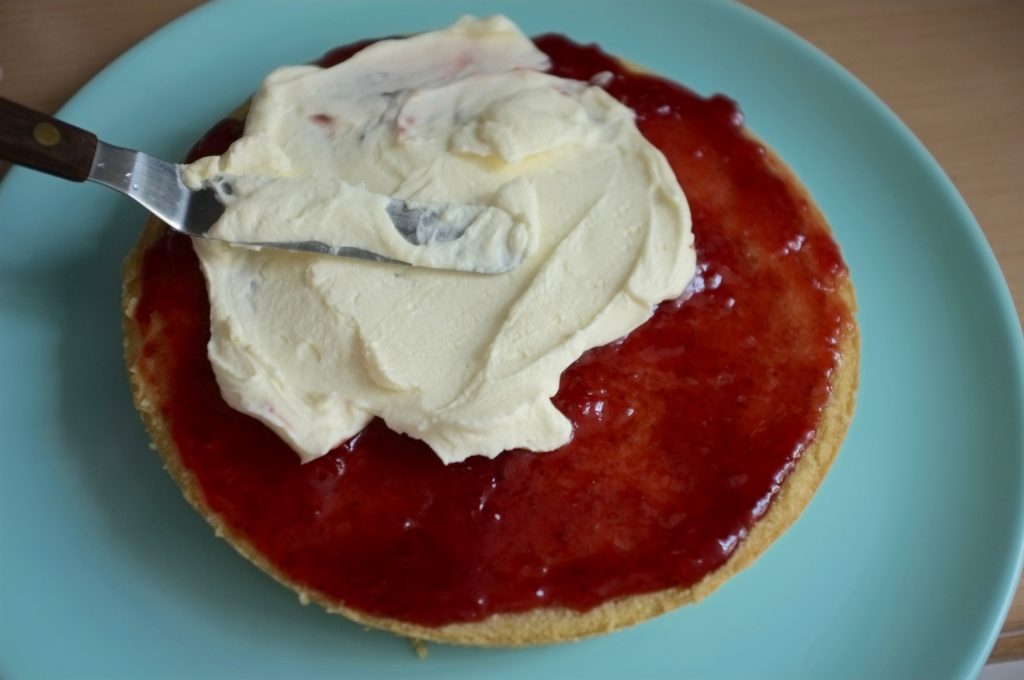 Au dessus de la confiture j'étale une génereuse couche de crème fouettée.