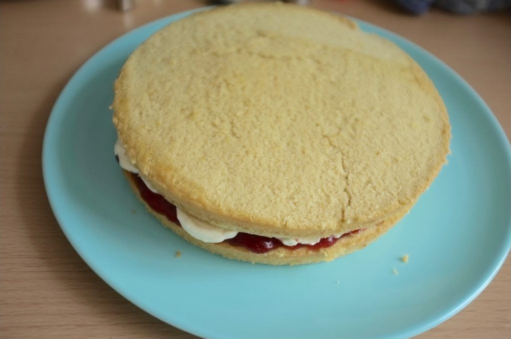 La seconde génoise est posée sur le premier gâteau sans gluten.