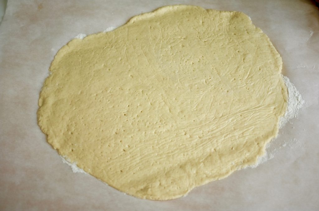 La pâte à pizza sans gluten étalée, prête à être cuite "à blanc".