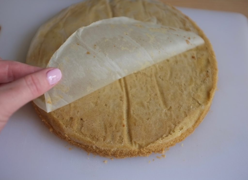 Le gâteau sans gluten est retourné et j'enlève la feuille de papier cuisson qui protégait le moule.