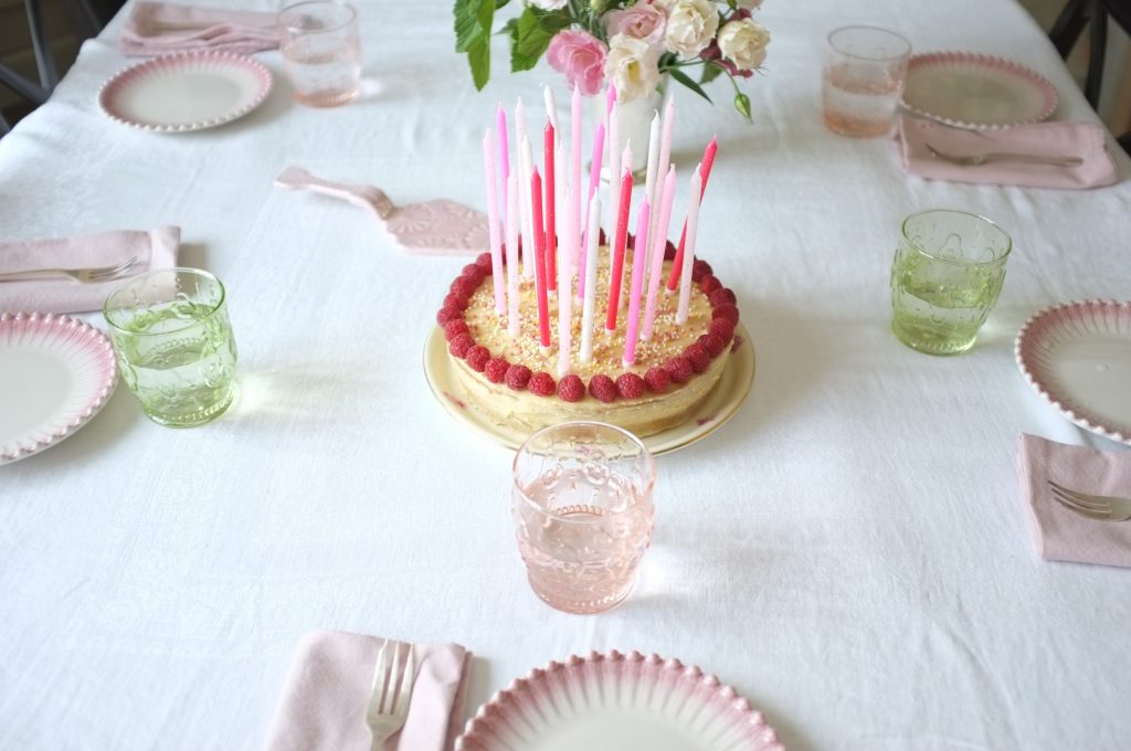 Mon gâteau d'anniversaire sans gluten à deux étages, parfumé à la vanille et décoré de framboises fraiches.