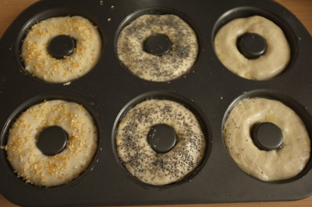 Avant d'être enfournés, je décore mes bagels sans gluten de graines de pavot, d'oignons en semoule et j'en garde certain "nature".