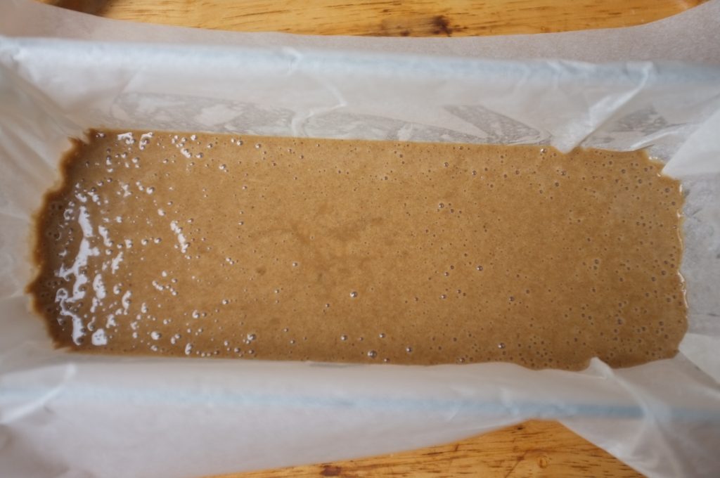La pâte sans gluten pour la pain d'épice à la farine de châtaigne est verser dans un moule à cake chemisé de papier cuisson.