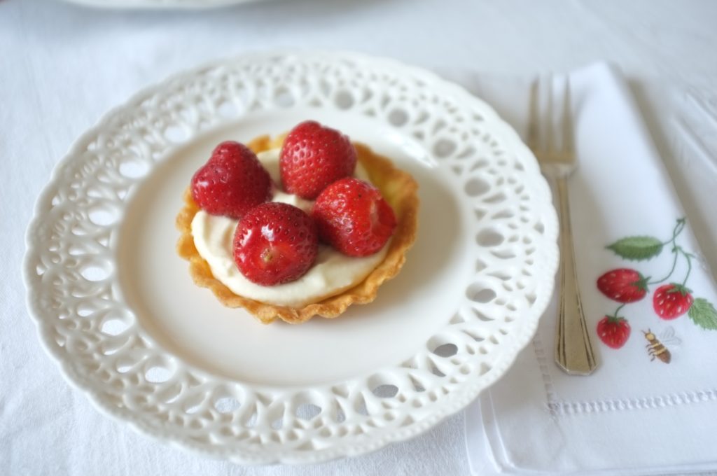 La tartellette sans gluten aux fraises, avec 4 belles fraises, déposé sur de la crême fouettée